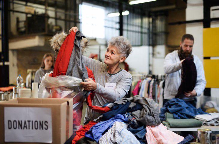 Freiwillige Helfer sortieren Kleidercontainer Spenden