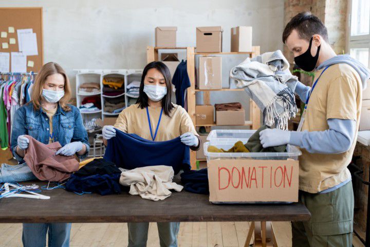 Junge Freiwillige sortieren Altkleidercontainer Spenden