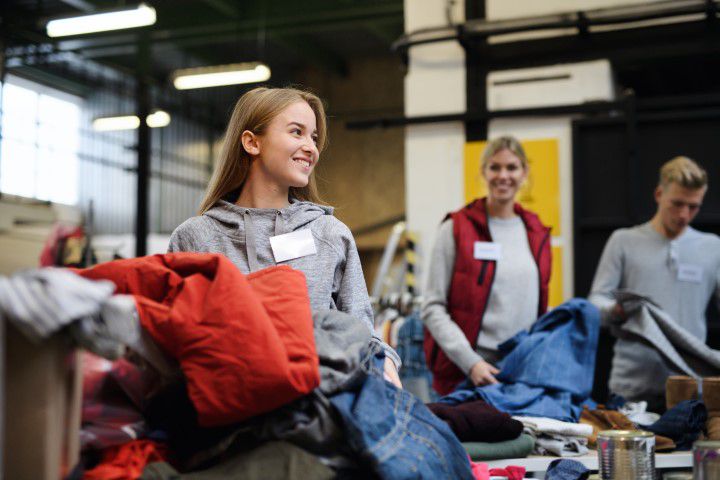 Junge Freiwillige sortieren gespendete Kleidung